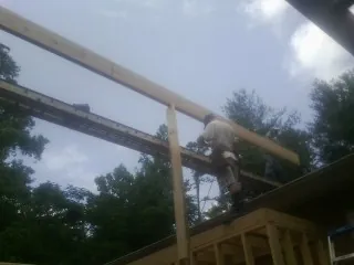 Carpenter setting a ridge beam over a new addition frame — Ice Dam Removal by Roofing Brothers in Fort Bridger