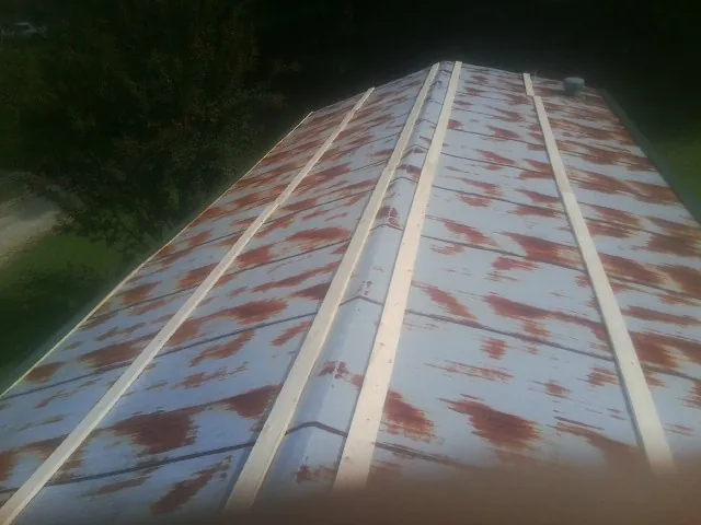 Rusted metal roof panels with new wood purlins before replacement — Storm Damage Roof Repair in Fort Bridger by Roofing Brothers