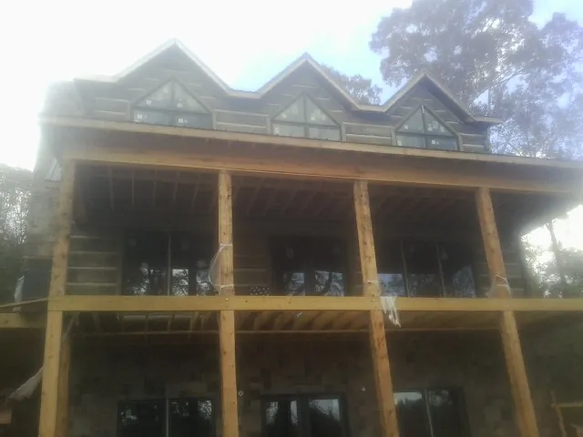 Dormers and porch framing on a large log home under construction — Roof Coating work by our crew in Fort Bridger