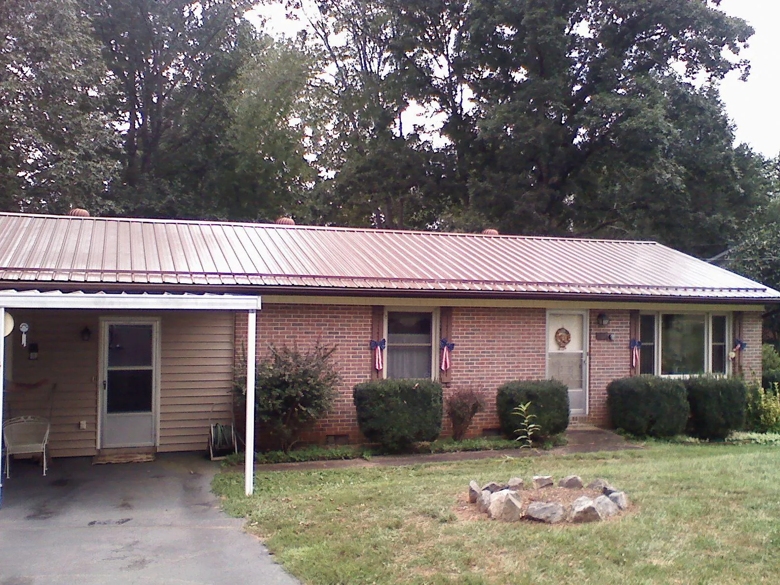 Bronze metal roof and carport on a brick ranch home — Roof Repair work by our crew in Fort Bridger