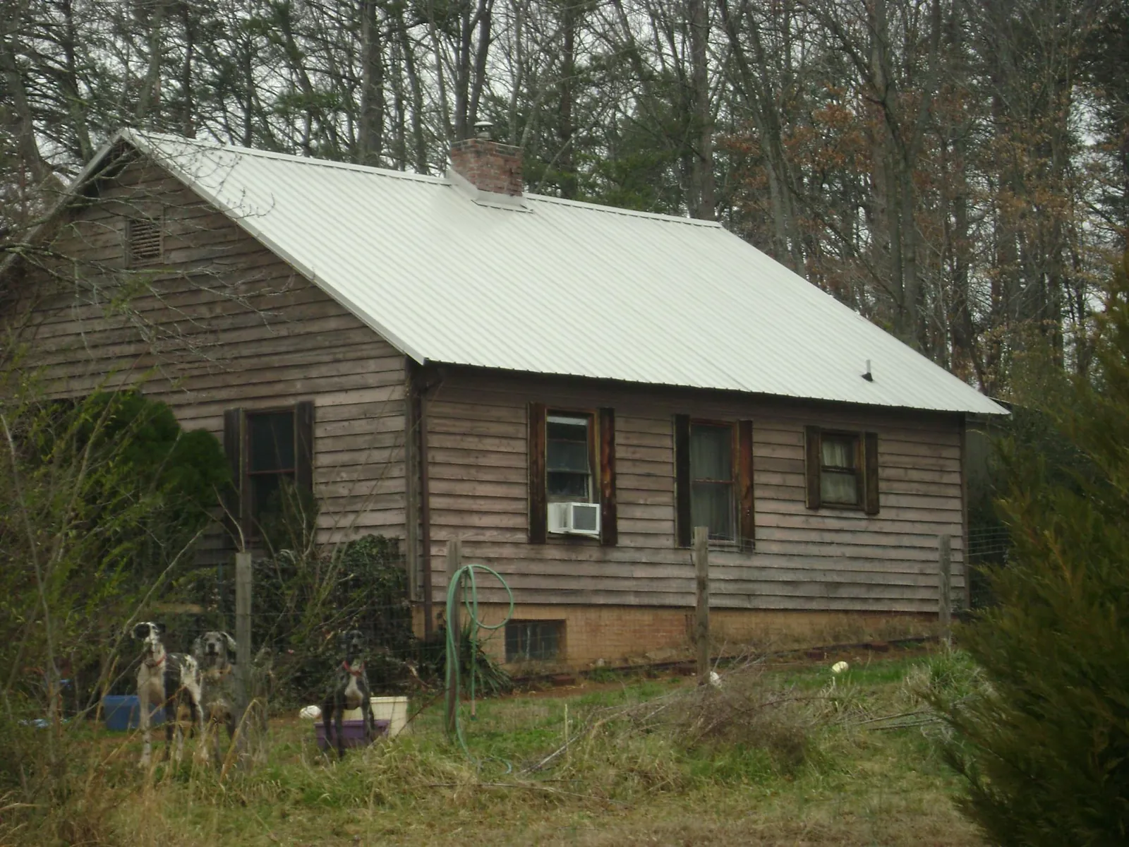 White metal roof on an old wood sided farmhouse, from a Metal Roof Installation job in Fort Bridger
